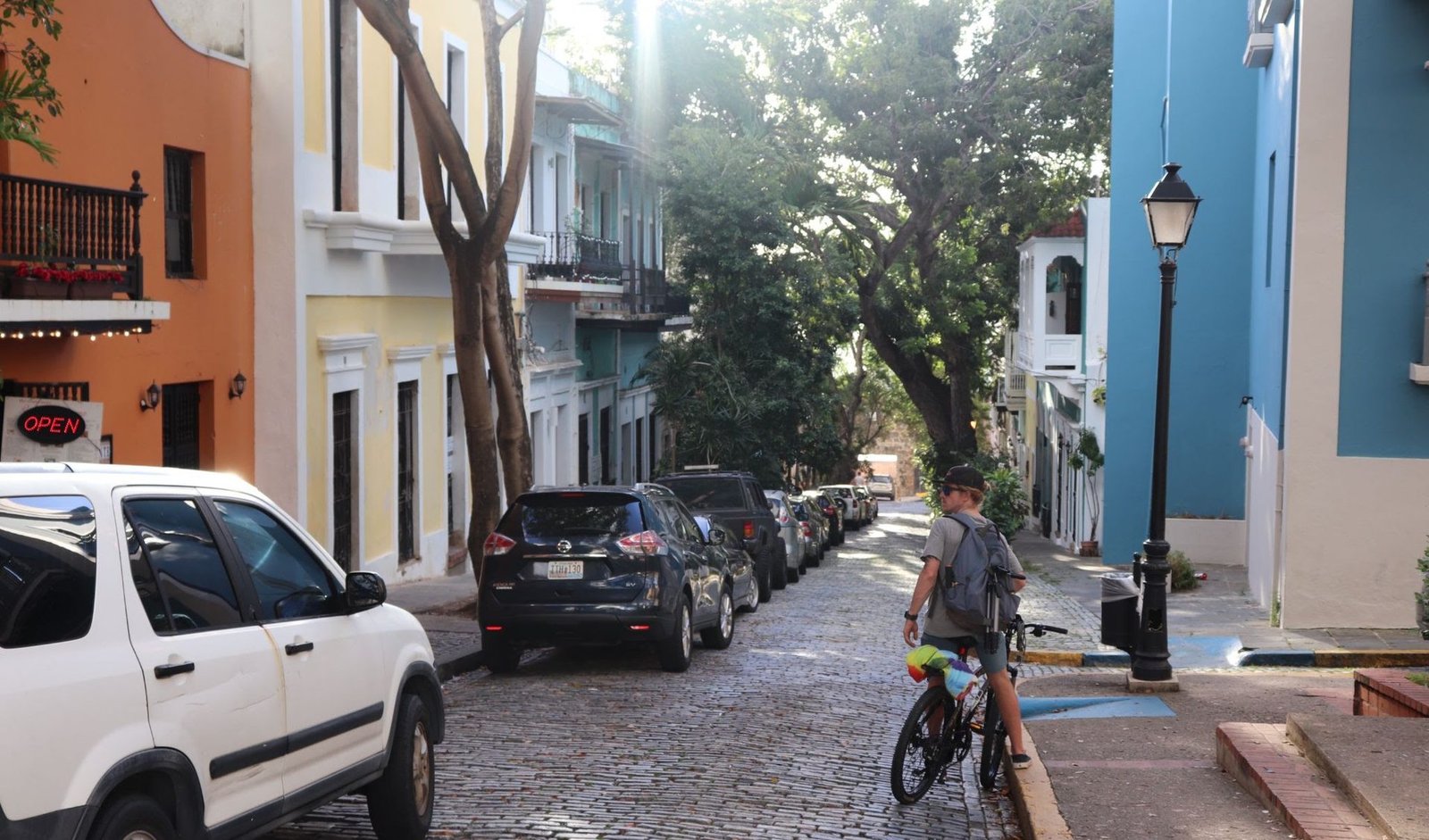 CJ riding a rental bike down a colourful street in Old San Juan