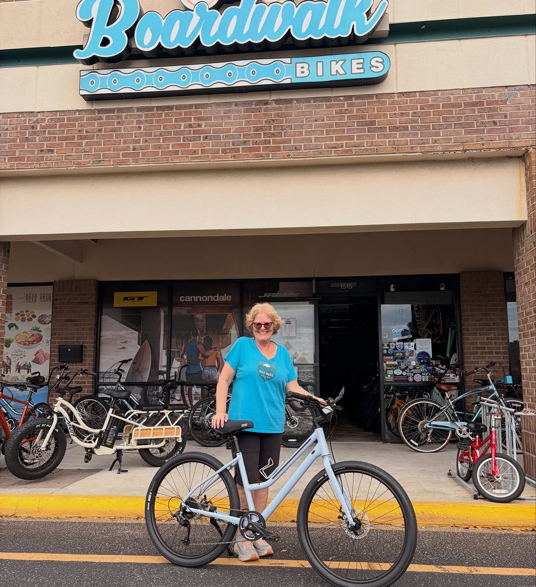 A customer with her new bike outside the Boardwalk Bikes storefront